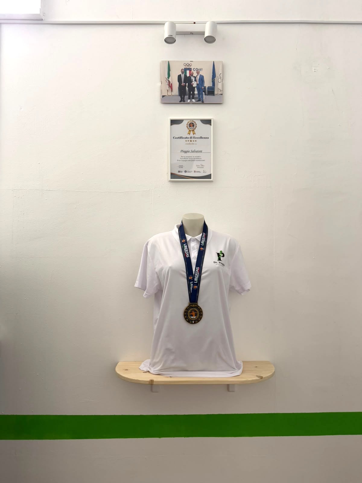 Maglia con medaglia, Certificato di Eccellenza e foto con il CONI esposti nello studio